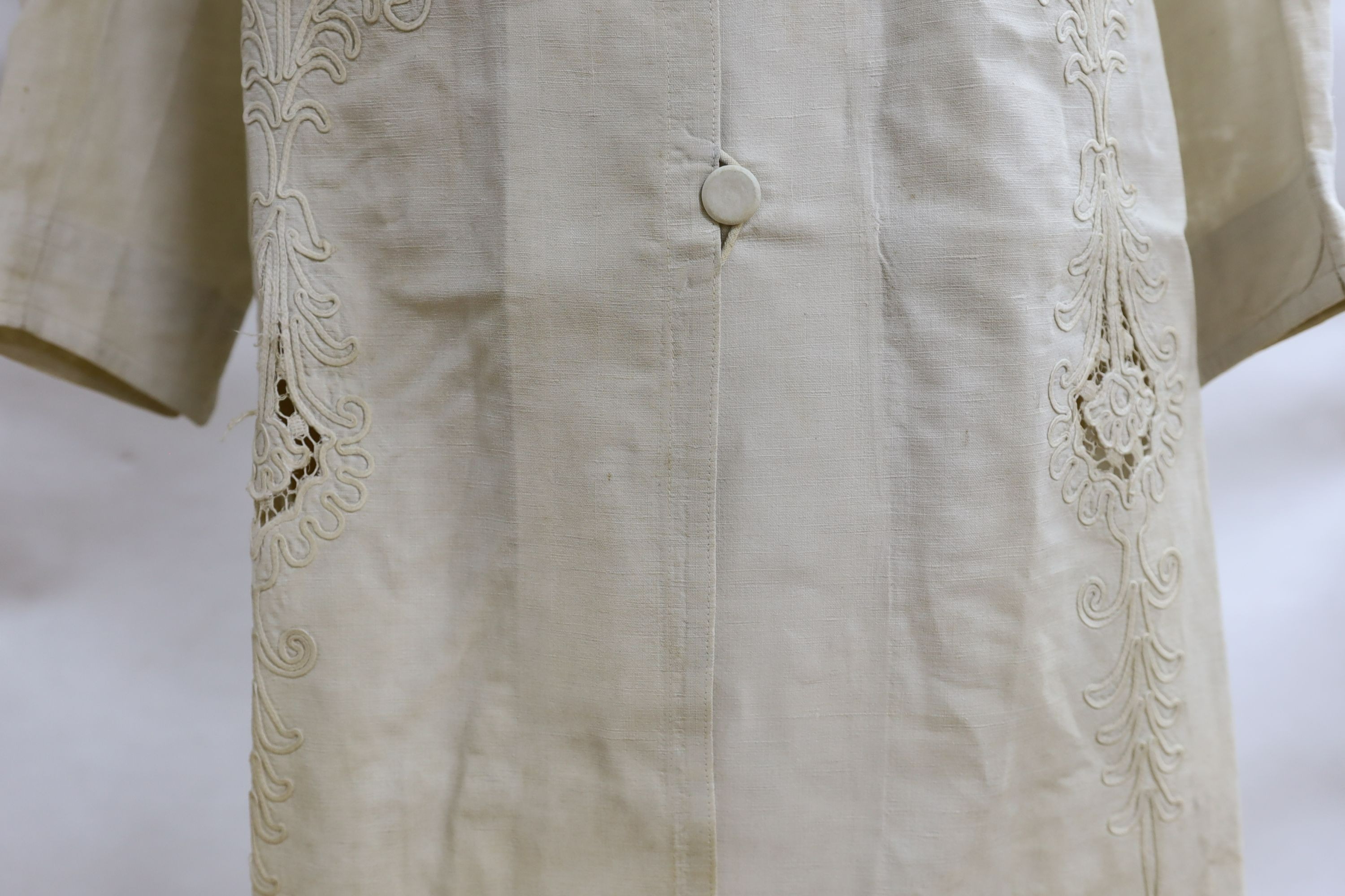 An Edwardian white/cream linen lady's coat with cut work detail and unusual button detail to the back